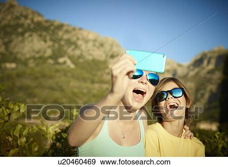 Sister and brother making faces for selfie on smartphone, Majorca, Spain View Large Photo Image Stock Photo - Sister and brother making faces for selfie on smartphone, Majorca, Spain. Fotosearch