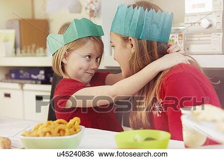 Sisters in paper crowns, hugging View Large Photo Image Stock Photograph - Sisters in paper crowns, hugging. Fotosearch