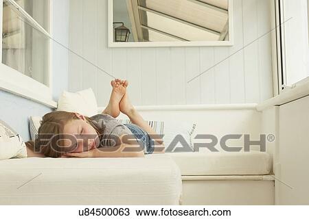 Sullen girl lying on holiday apartment seat View Large Photo Image Stock Image - Sullen girl lying on holiday apartment seat. Fotosearch