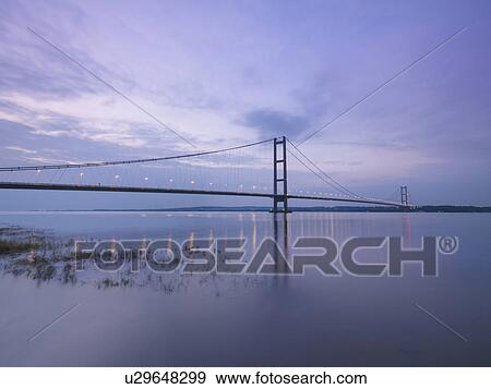 Stock Photo - Suspension bridge at sunset. The Humber Bridge, UK was built in 1981 and at the time was the world's largest single-span suspension bridge. Fotosearch