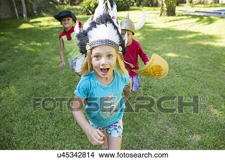 Picture - Three children wearing fancy dress costumes, playing in park. Fotosearch