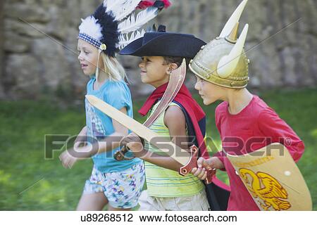 Three children wearing fancy dress costumes, playing in park View Large Photo Image Stock Image - Three children wearing fancy dress costumes, playing in park. Fotosearch