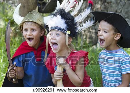 Three children wearing fancy dress costumes, playing in park View Large Photo Image Stock Image - Three children wearing fancy dress costumes, playing in park. Fotosearch