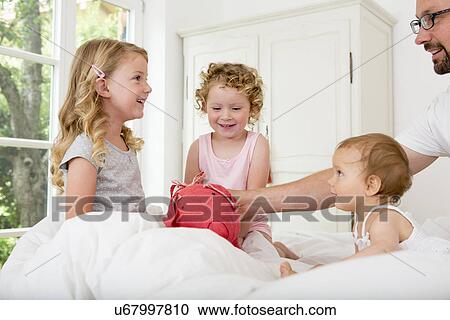 Three girls playing on bed View Large Photo Image Stock Image - Three girls playing on bed. Fotosearch