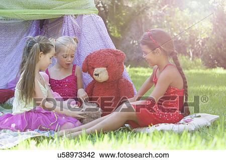 Three girls playing with teddy bears in garden View Large Photo Image Stock Image - Three girls playing with teddy bears in garden. Fotosearch