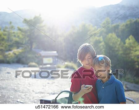 Two brothers looking at text on smartphone, Majorca, Spain View Large Photo Image Stock Photograph - Two brothers looking at text on smartphone, Majorca, Spain. Fotosearch