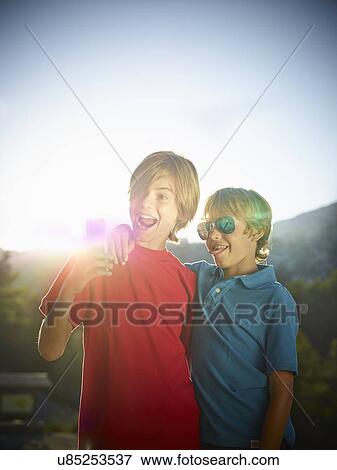 Two brothers making faces for selfie on smartphone, Majorca, Spain View Large Photo Image Stock Photo - Two brothers making faces for selfie on smartphone, Majorca, Spain. Fotosearch