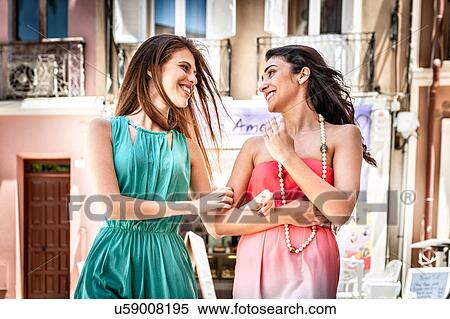 Stock Photography - Two fashionable young women chatting and strolling down street, Cagliari, Sardinia, Italy. Fotosearch