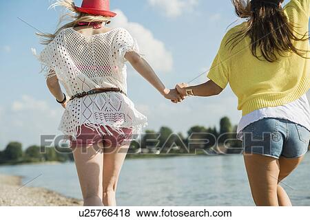 Two female friends holding hands View Large Photo Image Stock Photo - Two female friends holding hands. Fotosearch