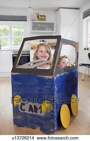 Picture - Two girls in homemade toy car. Fotosearch