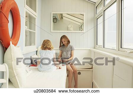 Two sisters playing cards in holiday apartment porch View Large Photo Image Picture - Two sisters playing cards in holiday apartment porch. Fotosearch