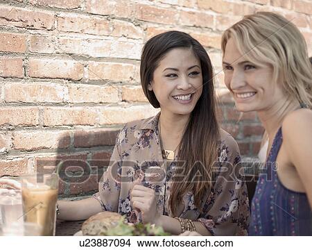 Two women, laughing, having lunch together View Large Photo Image Picture - Two women, laughing, having lunch together. Fotosearch
