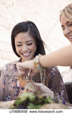 Two women, laughing, having lunch together View Large Photo Image Stock Photo - Two women, laughing, having lunch together. Fotosearch