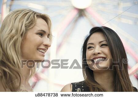 Stock Photo - Two women smiling at each other. Fotosearch