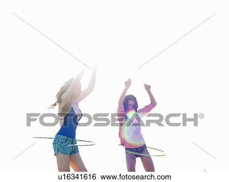 Two young women friends swinging hoola hoops on beach, Williamstown, Melbourne, Australia View Large Photo Image Stock Photograph - Two young women friends swinging hoola hoops on beach, Williamstown, Melbourne, Australia. Fotosearch