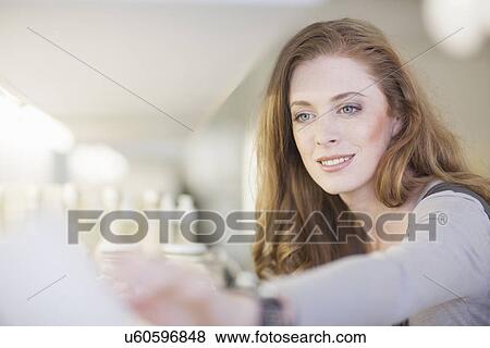 Stock Photo - Woman browsing products on display shelf. Fotosearch