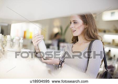 Woman browsing products on display shelf View Large Photo Image Stock Photography - Woman browsing products on display shelf. Fotosearch