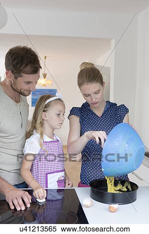 Stock Photography - Woman pouring cake mixture into baking tin. Fotosearch