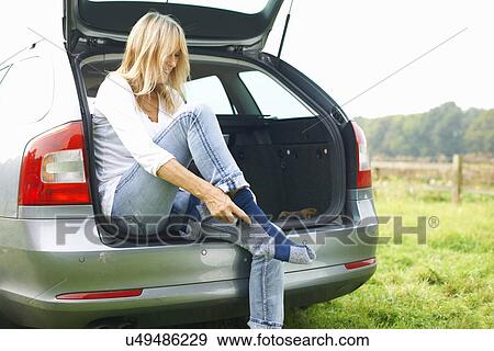 Woman sitting at rear of car putting on socks View Large Photo Image Stock Photo - Woman sitting at rear of car putting on socks. Fotosearch