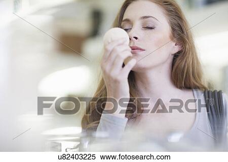 Stock Photography - Woman smelling product from display shelf. Fotosearch
