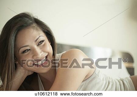 Woman, smiling, lying on bed View Large Photo Image Stock Photo - Woman, smiling, lying on bed. Fotosearch