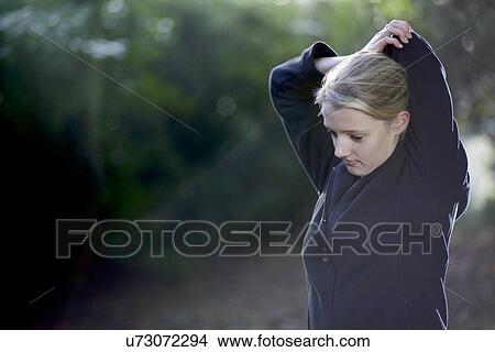 Picture - Woman stretching in woods. Fotosearch