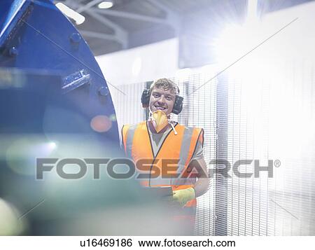 Stock Photograph - Worker in metal ore grinding mill. Fotosearch