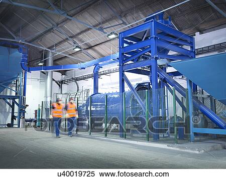 Stock Photography - Workers checking metal ore grinding mill. Fotosearch