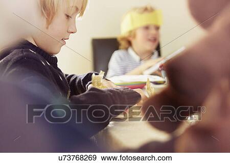 Young boy opening up Christmas present at table View Large Photo Image Stock Photo - Young boy opening up Christmas present at table. Fotosearch