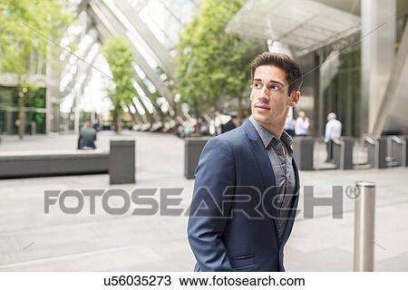 Young businessman looking over his shoulder at Broadgate Tower, London, UK View Large Photo Image Stock Image - Young businessman looking over his shoulder at Broadgate Tower, London, UK. Fotosearch