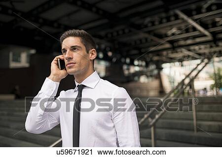 Young businessman outside station chatting on smartphone, London, UK View Large Photo Image Stock Image - Young businessman outside station chatting on smartphone, London, UK. Fotosearch