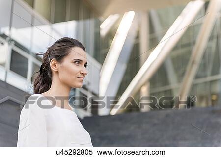 Stock Photography - Young businesswoman outside office building, London, UK. Fotosearch