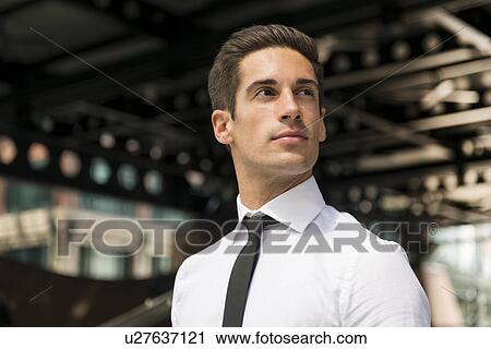 Stock Image - Young confident businessman outside station, London, UK. Fotosearch