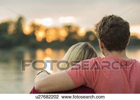 Young couple, man with arm around woman, rear view View Large Photo Image Stock Image - Young couple, man with arm around woman, rear view. Fotosearch