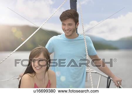 Young couple on bow of yacht sailing on lake under bright sunlight View Large Photo Image Stock Image - Young couple on bow of yacht sailing on lake under bright sunlight. Fotosearch