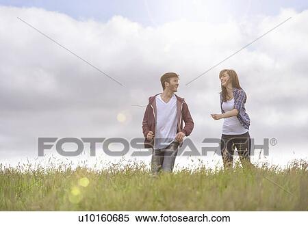 Young couple running through meadow under bright sunshine View Large Photo Image Stock Photography - Young couple running through meadow under bright sunshine. Fotosearch