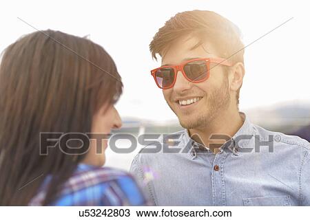 Stock Image - Young couple smiling on yacht during sunset. Fotosearch