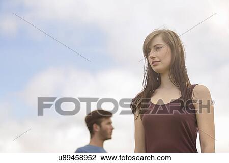 Young couple standing apart and looking away under bright blue sky View Large Photo Image Stock Image - Young couple standing apart and looking away under bright blue sky. Fotosearch