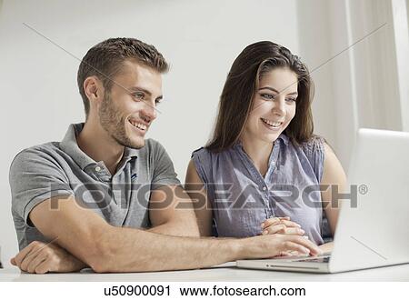 Stock Image - Young couple working on laptop. Fotosearch