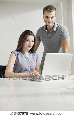Young couple working on laptop View Large Photo Image Stock Photography - Young couple working on laptop. Fotosearch