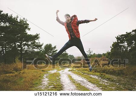 Young man jumping mid air on dirt track View Large Photo Image Stock Photograph - Young man jumping mid air on dirt track. Fotosearch