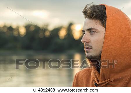 Young man wearing orange hooded top View Large Photo Image Stock Photo - Young man wearing orange hooded top. Fotosearch