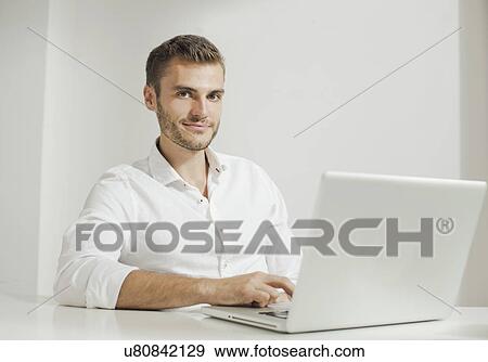 Young man working on laptop View Large Photo Image Stock Photo - Young man working on laptop. Fotosearch
