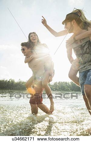 Young men giving young women piggy backs View Large Photo Image Stock Image - Young men giving young women piggy backs. Fotosearch