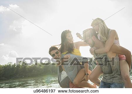 Young men giving young women piggy backs View Large Photo Image Stock Photo - Young men giving young women piggy backs. Fotosearch