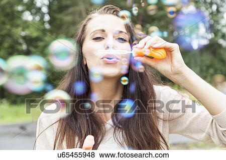 Young woman blowing bubbles View Large Photo Image Stock Photo - Young woman blowing bubbles. Fotosearch