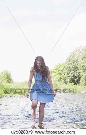 Young woman in shallow stream View Large Photo Image Stock Photo - Young woman in shallow stream. Fotosearch