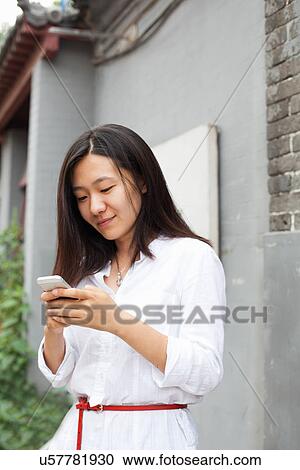 Young woman looking at mobile phone View Large Photo Image Stock Image - Young woman looking at mobile phone. Fotosearch