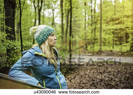 Young woman standing in forest looking away View Large Photo Image Stock Photograph - Young woman standing in forest looking away. Fotosearch