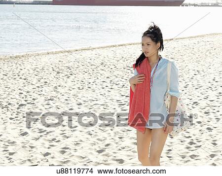 Young woman strolling on beach with beach towel, Port Melbourne, Melbourne, Victoria, Australia View Large Photo Image Picture - Young woman strolling on beach with beach towel, Port Melbourne, Melbourne, Victoria, Australia. Fotosearch